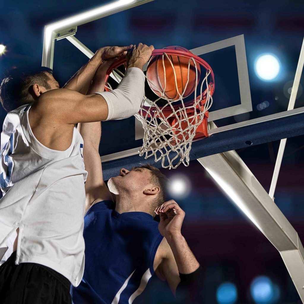 Two basketball players in action in gym